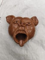 Handmade terracotta mask in a tribal style – a reddish-brown showpiece.